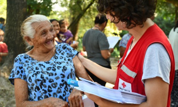Personal de Cruz Roja con una mujer de edad avanzada