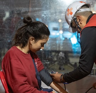 Personal de Cruz Roja tomando la presión a una mujer